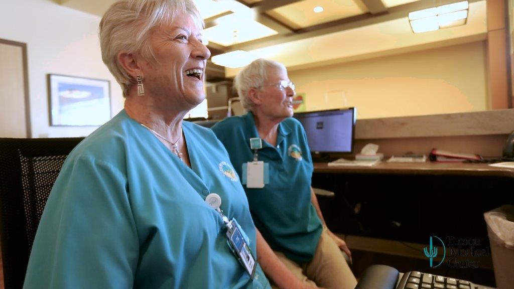 Two women volunteering at information desk